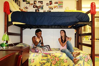 两个女学生坐在宿舍的床上