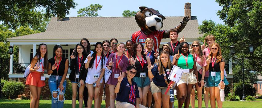 Orientation leaders with students in front of Southpaw statue.